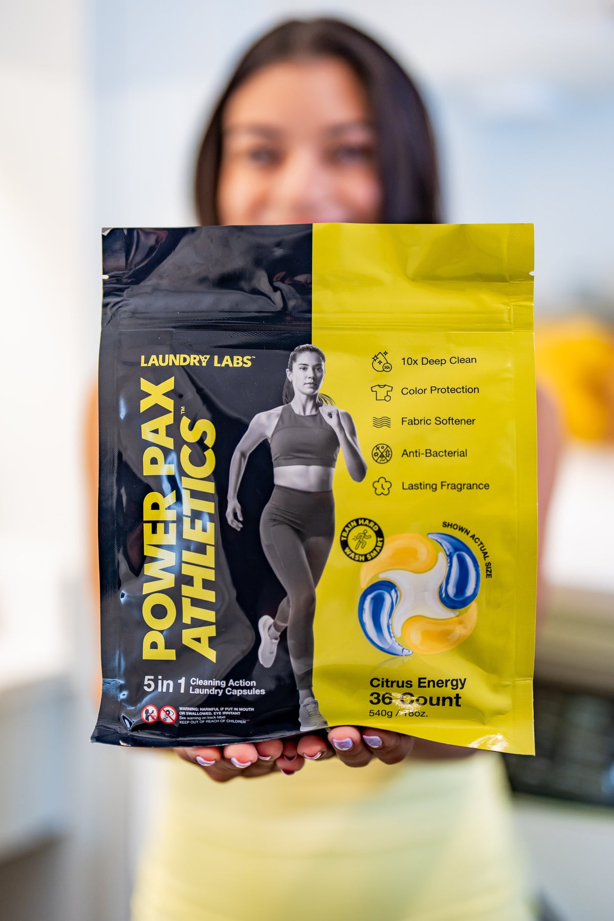 Person holding a laundry product packaging with 'Laundry Labs' branding