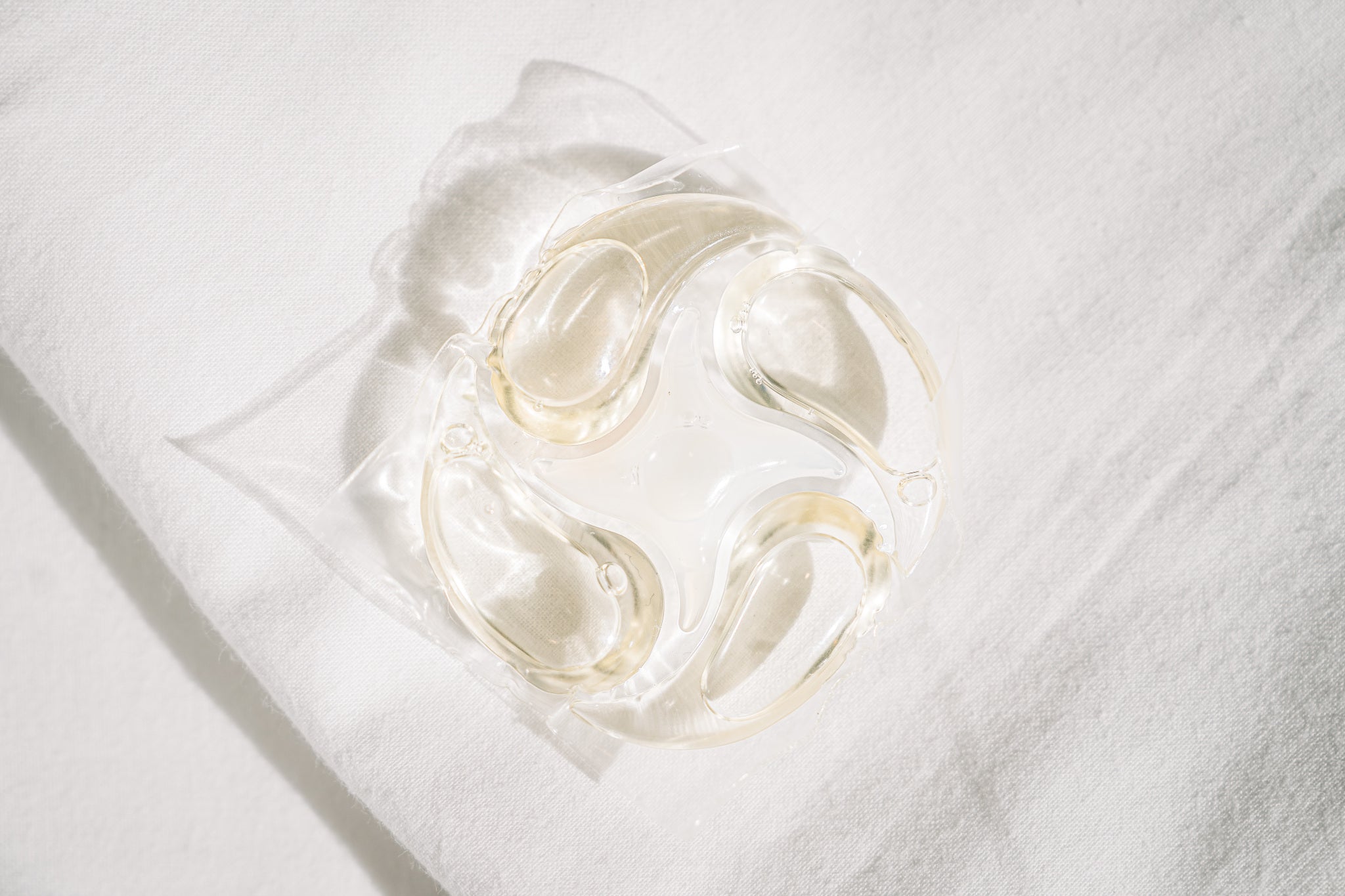 PowerPax capsule resting on white folded laundry
