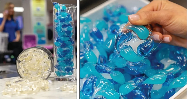 Blue gel beads in a container and being held by a hand with a blurred background.